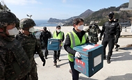 28일 울릉도 해군부대 헬기장에 도착한 코로나19 백신이 군 장병들의 경계 속 울릉군 보건소로 옮겨지고 있다.