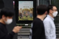 27일 광화문인근 영화관에 설치된 미나리 포스터에 시민들의 눈길이 가고 있다. 한국영화에 새 역사를 쓴 영화 ‘미나리’는 한국 배우 최초로 아카데미 여우조연상을 수상한 배우 윤여정씨가 출연한 영화이다.