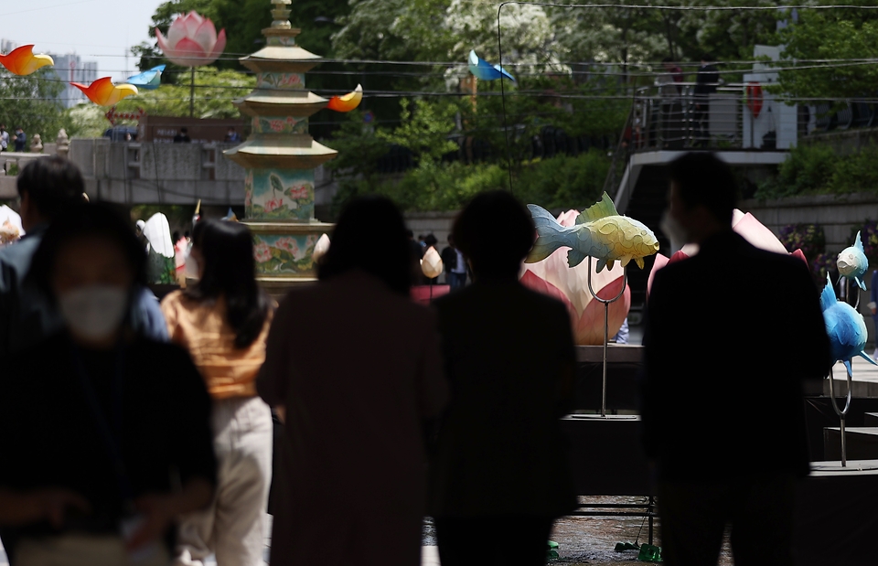 11일 서울 종로구 청계천에 석가탄신일을 앞두고 연등이 설치되어 점심시간 시민들이 주위를 둘러보고 휴식을 취하고 있다