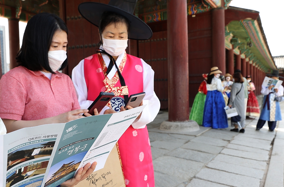 <p>11일 서울 종로구 경복궁 자유 관람에 참여한 청각장애인들이 경복궁 안내실에 비치된 수어해설 전용 홍보물에 탑재된 정보무늬(QR 코드)를 모바일로 인식시키면 펼쳐지는 수어해설영상을 보면서 경복궁을 관람하고 있다. 이날 관계자 및 경복궁 해설사들이 QR 코드 인식 방법 등을 설명해주며 함께 관람시간을 보냈다.</p>