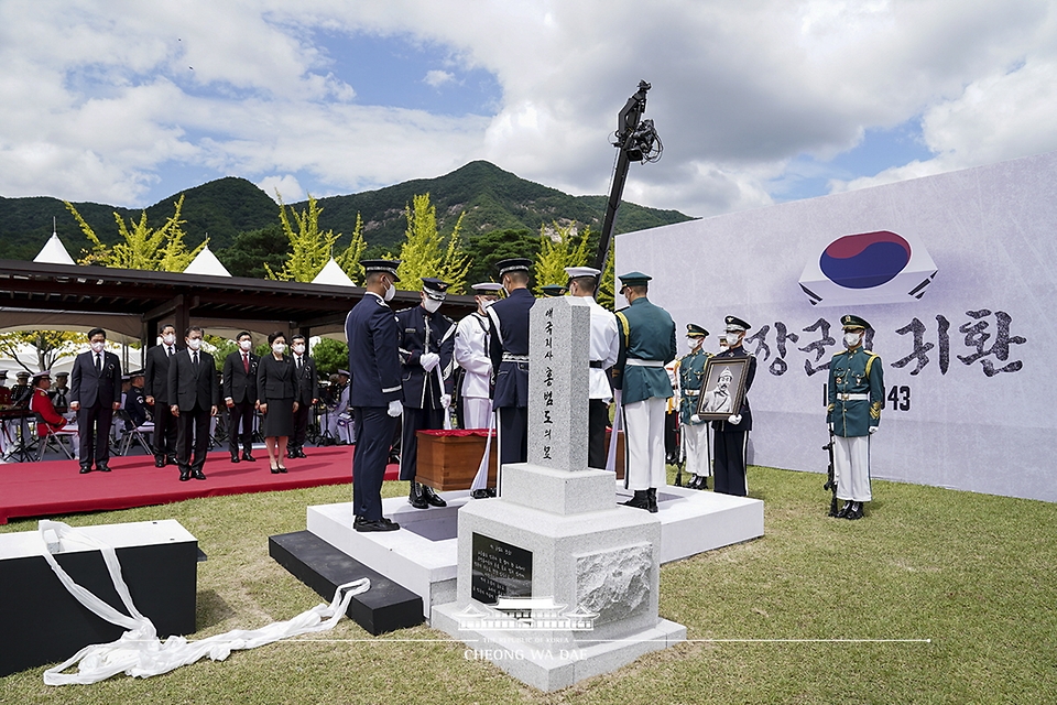 문재인 대통령과 김정숙 여사를 비롯한 참석자들이 18일 국립대전현충원에서 열린 고 홍범도 장군 유해 안장식에서 하관을 지켜보고 있다.