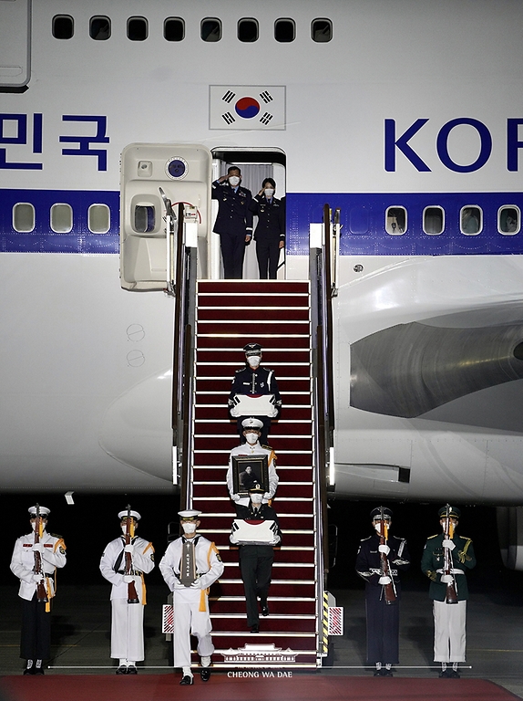 23일 밤 서울공항에서 열린 국군 전사자 유해 봉환식에서 문재인 대통령과 함께 귀국한 국군 전사자 유해가 하기되고 있다.