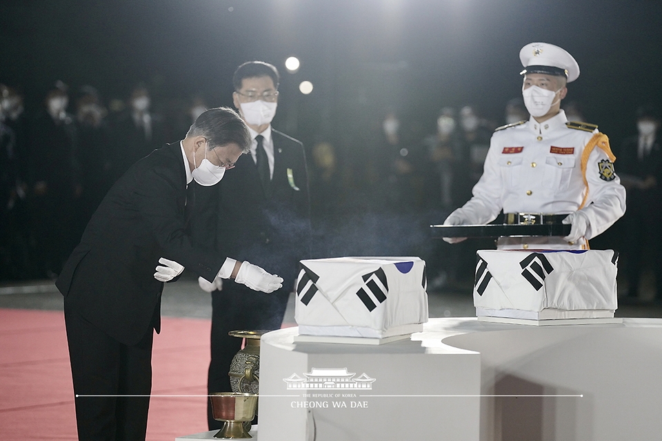 방미 일정을 마치고 귀국한 문재인 대통령이 23일 밤 서울공항에서 열린 국군 전사자 유해 봉환식에서 유해 앞에서 예를 갖추고 있다. 