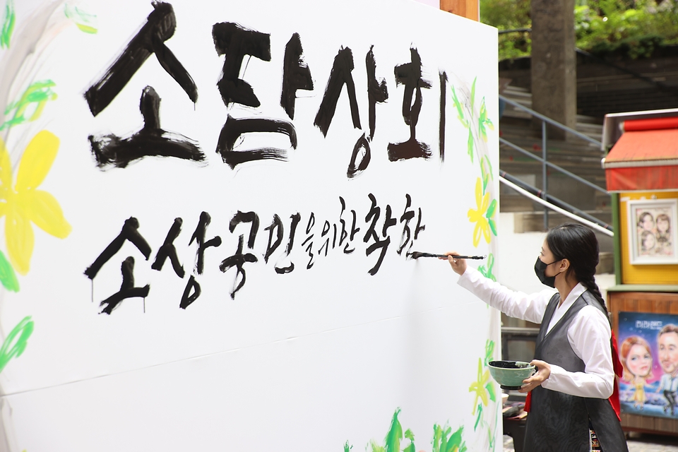 15일 서울 인사동 쌈지길에서 열린 소상공인 플래그십 스토어 개장행사에서 명인의 대형 붓글씨 연출을 통해 코로나19로 지친 소상공인을 위로하고 있다.