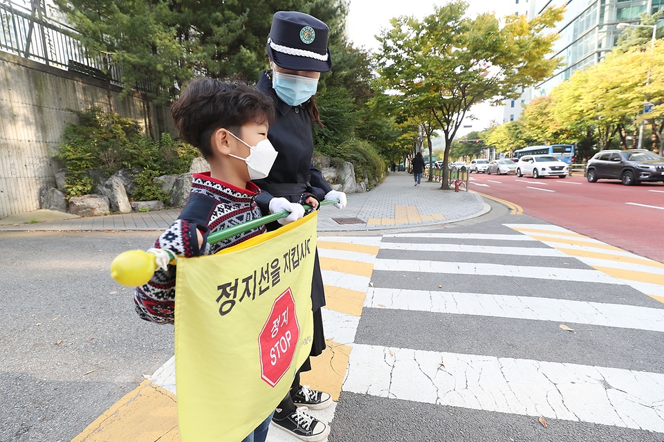 <p>개정 도로교통법이 첫 시행된 21일 오전 서울 마포구 한 초등학교 앞에서 한 학부모가 교통 지도를 하고 있다. 오늘(21일)부터 어린이보호구역(스쿨존) 내 모든 도로에서 차량 주&middot;정차가 전면 금지된다.&nbsp;</p>
<div><br></div>