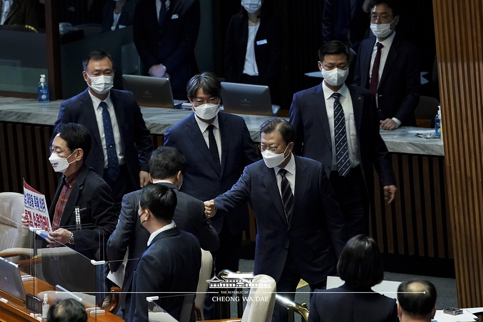 문재인 대통령이 25일 2022년도 예산안 시정연설을 하기 위해 국회 본회의장으로 입장하며 의원들과 인사나누고 있다.