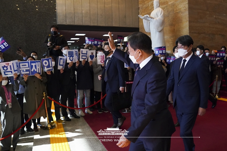 문재인 대통령이 25일 2022년도 예산안 시정연설을 마치고 국회 본청을 나서며 응원하는 당직자들을 향해 손인사를 하고 있다.