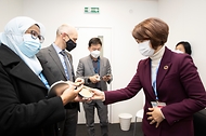 한정애 환경부 장관이 4일(현지 시간) 영국 글래스고에서 열린 제26차 유엔기후변화협약 당사국총회(COP26)에서 마이무나 모드 샤리프(Maimunah Mohd Sharif) 유엔 해비타트 사무총장을 만나 달고나를 선물하고 있다.