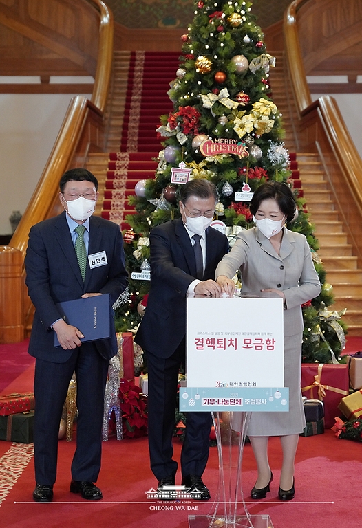 문재인 대통령과 부인 김정숙 여사가 3일 청와대에서 열린 ‘2021 기부·나눔단체 초청행사’에서 대한결핵협회에 성금을 기부하고 있다. 