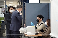 문재인 대통령이 4일 삼청동 주민센터에 마련된 제20대 대통령 선거 사전투표소에서 본인 확인을 위해 마스크를 내리고 있다.
