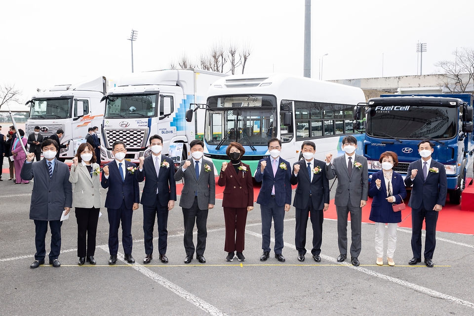 한정애 환경부장관(왼쪽 여섯번째)이 24일 오전 경기도 평택시 시립운동장에서 열린 수소모빌리티 특구 조성 업무 협약식을 마치고 협약에 참여한 관계기관 대표들과 전시되어 있는 수소 상용차를 배경으로 기념촬영을 하고 있다.