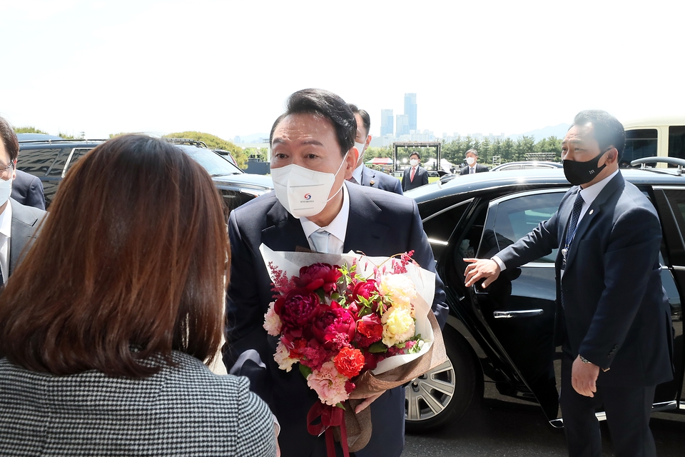 윤석열 대통령이 10일 서울 용산에 마련된 대통령실 청사에 도착해 직원으로부터 꽃다발을 받고 있다.