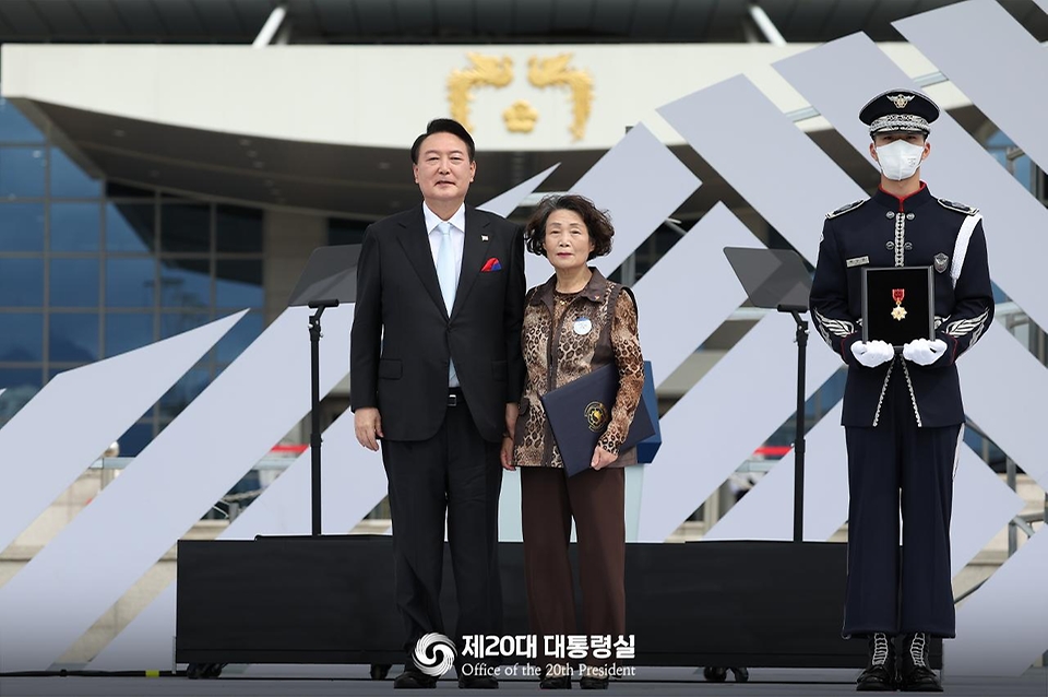 윤석열 대통령이 15일 서울 용산구 대통령실 잔디마당에서 열린 제77주년 광복절 경축식에서 고 이두규 지사에게 건국훈장 애족장을 추서한 뒤 손녀 김복식씨와 기념촬영을 하고 있다.