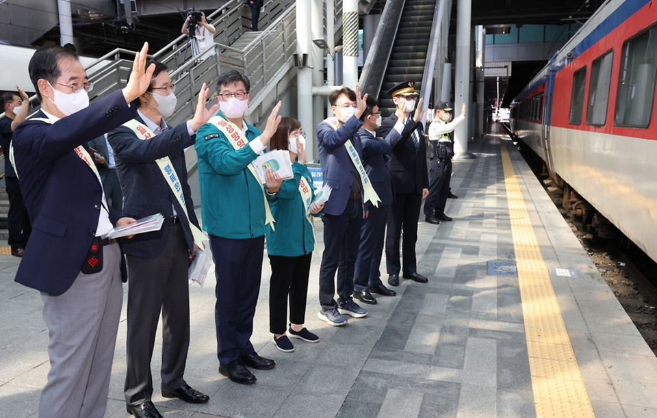 이기일 보건복지부 제2차관이 추석 연휴 시작일인 9일 서울 용산구 용산역에서 열린 방역수칙 및 연휴 중 의료기관 이용 안내서(리플렛) 배부 행사에 참석해 관계자들과 열차를 향해 인사를 하고 있다.