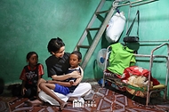 김건희 여사가 12일(현지시간) 프놈펜 선천성 심장질환을 앓고 있는 14세 아동의 집을 찾아 건강상태를 살피며 위로하고 있다.