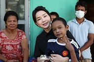 김건희 여사가 12일(현지시간) 캄보디아 프놈펜에서 선천성 심장질환을 앓고 있는 14세 아동의 집을 찾아 아이를 안고 있다.