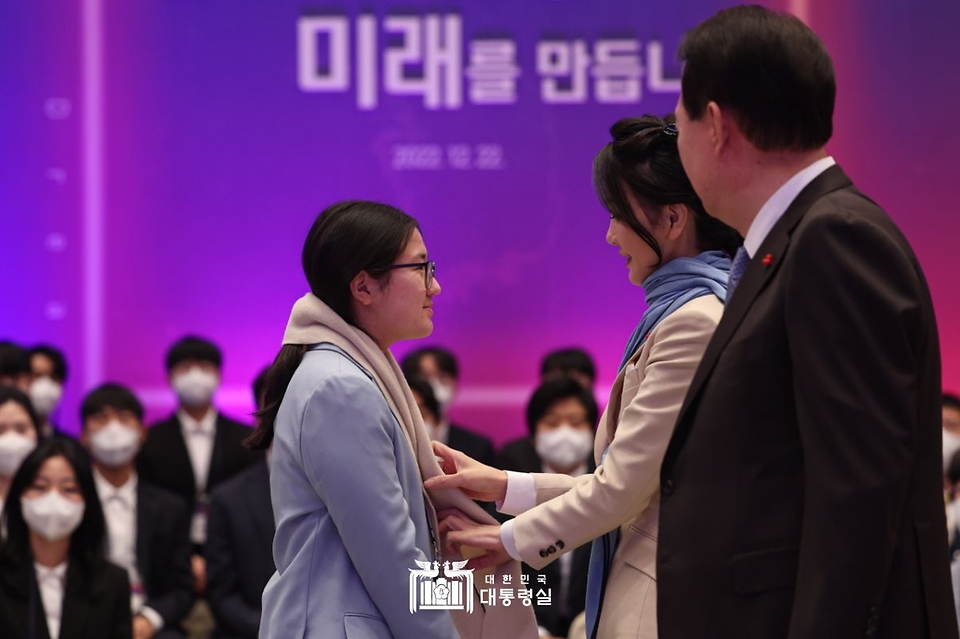 김건희 여사가 22일 서울 청와대 영빈관에서 열린 ‘미래 과학자와의 대화’에서 국제 과학올림피아드 수상자 함주현 양에게 목도리를 매주고 있다.