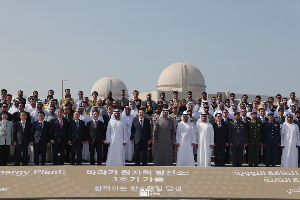 윤석열 대통령과 모하메드 빈 자이드 알 나흐얀 UAE 대통령이 16일(현지시간) 아랍에미리트 아부다비 알다프라에 위치한 바라카 원자력발전소에서 열린 바라카 원전 3호기 가동식에서 관계자들과 기념촬영을 하고 있다.