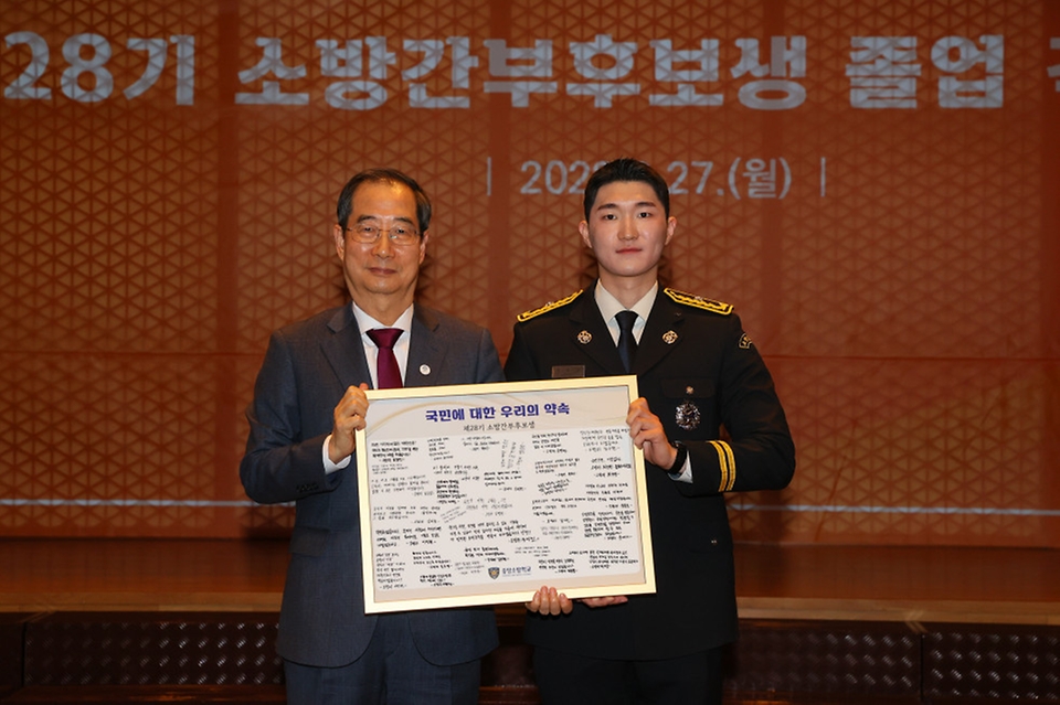 한덕수 국무총리가 27일 세종시 국무총리공관에서 열린 소방간부후보생 졸업 격려 만찬에서 ‘국민에 대한 우리의 약속’ 액자를 전달받은 뒤 기념촬영을 하고 있다.