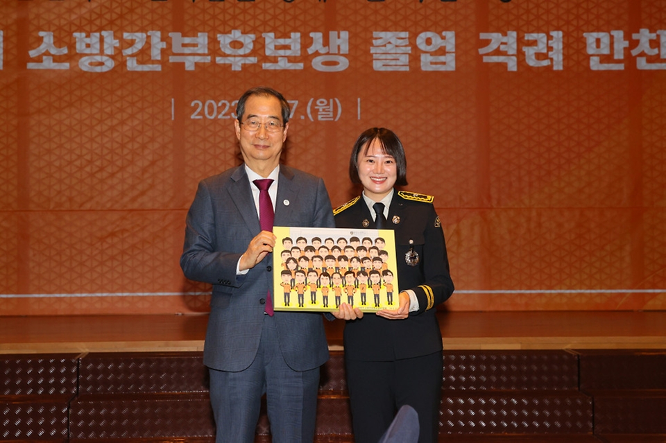 한덕수 국무총리가 27일 세종시 국무총리공관에서 열린 소방간부후보생 졸업 격려 만찬에서 ‘총리님과 함께’ 등이 담긴 캐리커처를 전달받은 뒤 기념촬영을 하고 있다. 