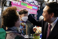 윤석열 대통령이 9일 울산시 남구 신정시장을 방문해 아이의 머리를 쓰다듬으며 인사하고 있다.