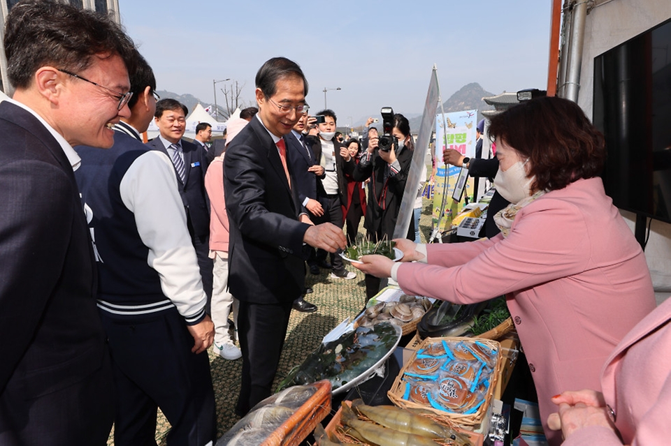 한덕수 국무총리가 22일 서울 종로구 광화문 광장에서 열린 전남 방문의 해 홍보 행사장에서 떡을 시식하고 있다.