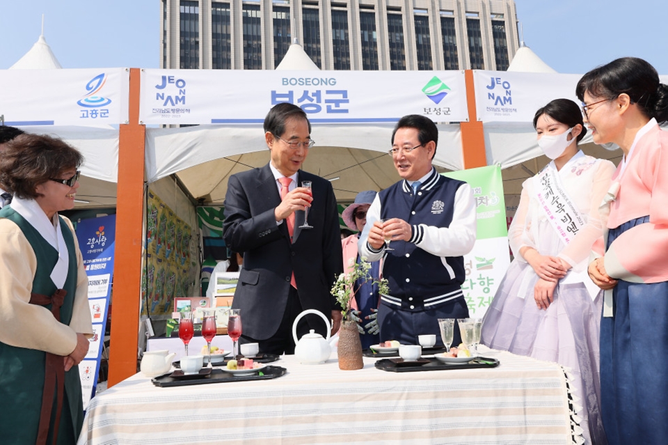 한덕수 국무총리가 22일 서울 종로구 광화문 광장에서 열린 전남 방문의 해 홍보 행사장에서 김영록 전남지사와 보성차를 시음하고 있다.