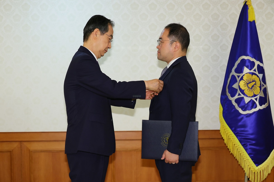 한덕수 국무총리가 24일 서울 종로구 정부서울청사에서 열린 ‘정부업무평가 유공자 포상전수식’에서 박진홍 국토교통부 과장에게 녹조 근정훈장을 수여하고 있다.