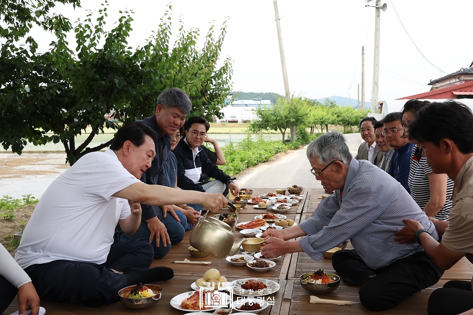 윤석열 대통령이 7일 충남 부여군 꿈에영농조합법인을 방문해 모내기를 마친 뒤 주민들과 새참을 먹고 있다.