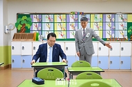 윤석열 대통령이 3일 방과 후 돌봄·교육 프로그램인 ‘늘봄학교’ 참관을 위해 경기도 수원시 수원초등학교를 방문, 책상에 앉아 추홍엽 수원초등학교 교장의 설명을 듣고 있다.