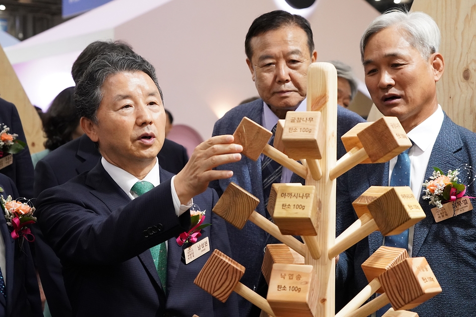 남성현 산림청장이 25일 경기 고양시 킨텍스에서 열린 ‘2023년 대한민국 목재산업박람회’에서 최무열 한국임업인총연합회장 및 주요 내빈들과 전시 부스를 둘러보며 목재를 만져보고 있다.