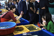 김건희 여사가 14일 부산 수영구 민락어민활어직판장을 방문해 어린이와 기념촬영을 하고 있다.