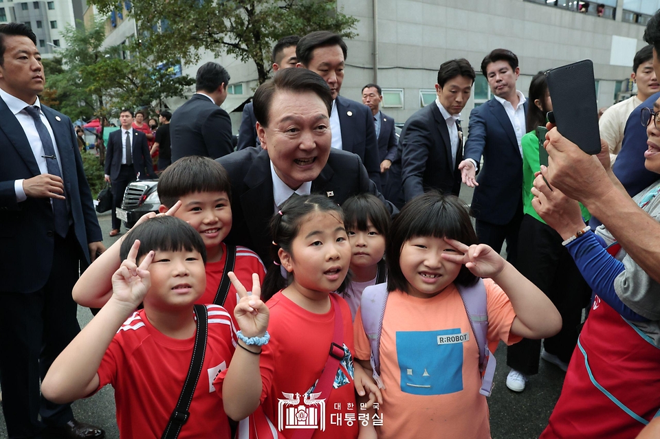윤석열 대통령이 14일 부산 수영구 민락어민활어직판장을 방문해 어린이들과 기념촬영을 하고 있다.
