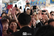 윤석열 대통령이 14일 부산 수영구 민락어민활어직판장을 방문해 시민들에게 인사하고 있다.