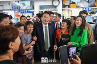 윤석열 대통령과 김건희 여사가 14일 부산 수영구 민락어민활어직판장을 방문해 상인 및 시민들과 기념촬영을 하고 있다. 