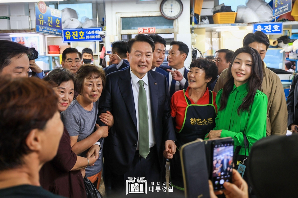 윤석열 대통령과 김건희 여사가 14일 부산 수영구 민락어민활어직판장을 방문해 상인 및 시민들과 기념촬영을 하고 있다. 