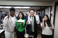 윤석열 대통령과 김건희 여사가 14일 부산 수영구 민락어민활어직판장 인근 식당에서 적도기니에서 온 온유 씨와 부산 지역 청년들이 선물한 ‘2030 부산세계박람회 유치 기원 커스텀 슈즈’를 들고 기념촬영을 하고 있다.
