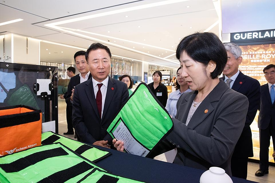 한화진 환경부 장관이 15일 서울 중구 신세계면세점 명동점에서 매장을 방문해 관계자로부터 포장 개선 방식과 포장과정에 대한 설명을 듣고 있다.