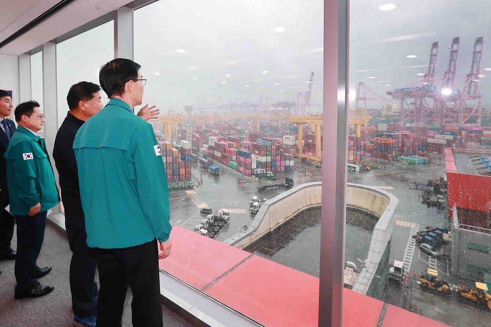 방문규 산업통상자원부 장관이 20일 부산신항 내 3부두 한진터미널을 방문해 홍보관 전망대에서 화물선적과 하역 현장을 살펴보고 있다.