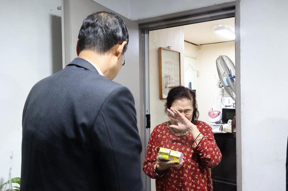 한덕수 국무총리가 26일 서울 성동구 주택가를 찾아 홀로 살고 있는 박인애 씨에게 우유를 배달한 뒤 안부를 묻고 있다.