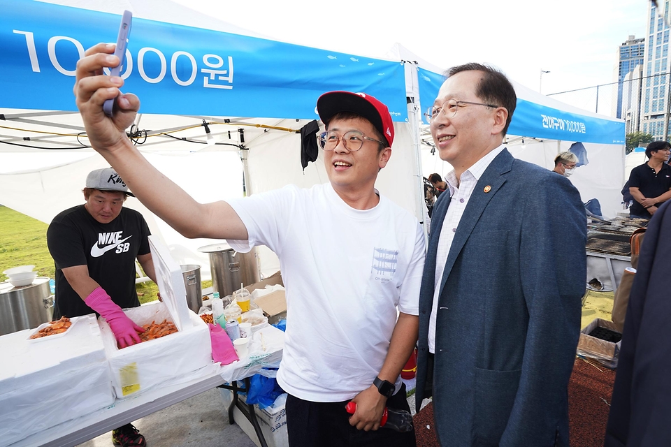 조승환 해양수산부 장관이 23일 서울 동작구 노량진수산시장에서 열린 ‘노량진수산시장 수산대축제’에 참석해 시민과 셀카를 찍고 있다.