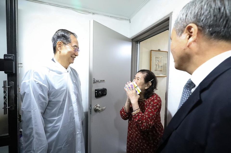 한덕수 국무총리가 26일 서울 성동구 주택가를 찾아 홀로 살고 있는 박인애 씨에게 우유를 배달한 뒤 안부를 묻고 있다.