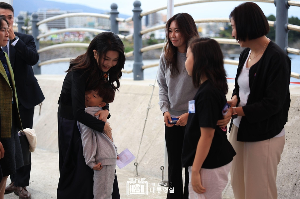 김건희 여사가 제주 서귀포시 서귀포항에서 열린 ‘제4회 제주 서귀포 은갈치 축제 개막식’에 참석해 어린이를 안아주고 있다.