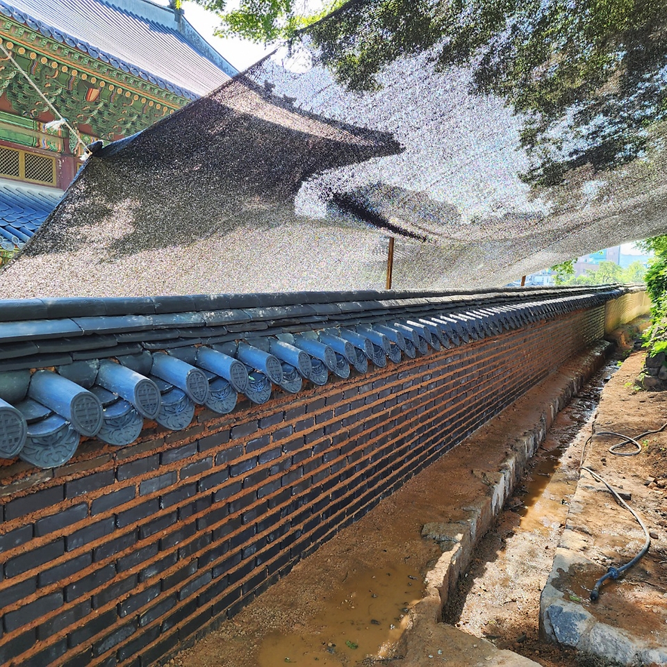 지난 7월 집중호우로 붕괴된 서울 종로구 창덕궁 인정전 담장을 작업자들이 복구하고 있다.