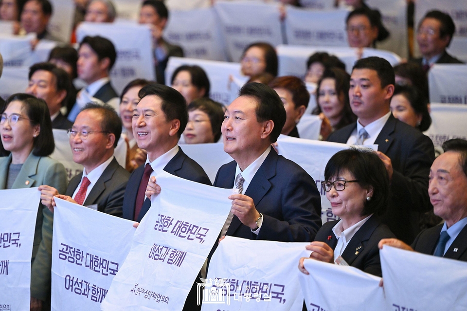 윤석열 대통령이 1일 서울 강남구 코엑스에서 열린 ‘제58회 전국여성대회’에서 참석자들과 ‘공정한 대한민국 여성과 함께’라는 문구를 들고 퍼포먼스를 하고 있다.