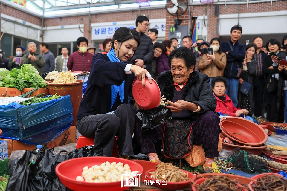 김건희 여사가 7일 전남 순천시 아랫장 전통시장을 방문해 채소를 구매하고 있다.