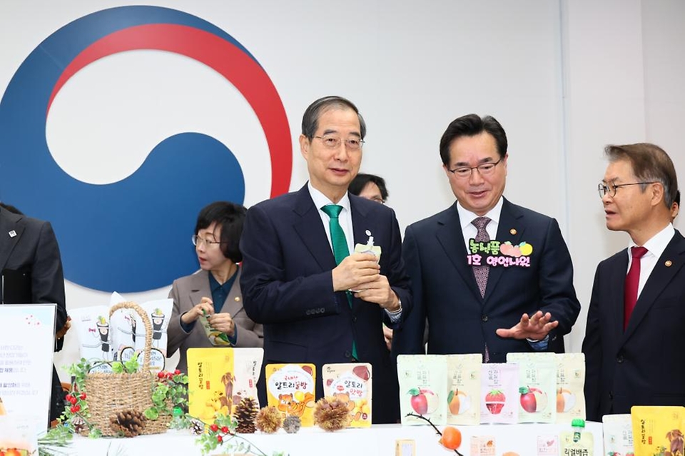 한덕수 국무총리가 21일 서울 종로구 정부서울청사에서 열린 ‘우수 농식품 홍보행사’에서 정황근 농림축산식품부 장관의 설명을 듣고 있다.