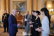 22일(현지시간) 영국 런던 버킹엄궁에서 열린 ‘문화 예술인 격려행사’에서 찰스 3세(Charles III) 영국 국왕이 블랙핑크 멤버들에게 대영제국훈장을 수여한 뒤 대화하고 있다.