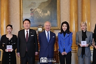 윤석열 대통령과 김건희 여사가 22일(현지시간) 영국 런던 버킹엄궁에서 열린 ‘문화 예술인 격려행사’에서 찰스 3세(Charles III) 영국 국왕, 블랙핑크 멤버들과 기념촬영을 하고 있다.