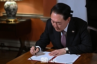 윤석열 대통령이 22일(현지시간) 영국 런던 다우닝가 10번지 총리 관저에서 ‘한·영 정상회담’을 마친 뒤 ‘다우닝가 합의’에 서명하고 있다.